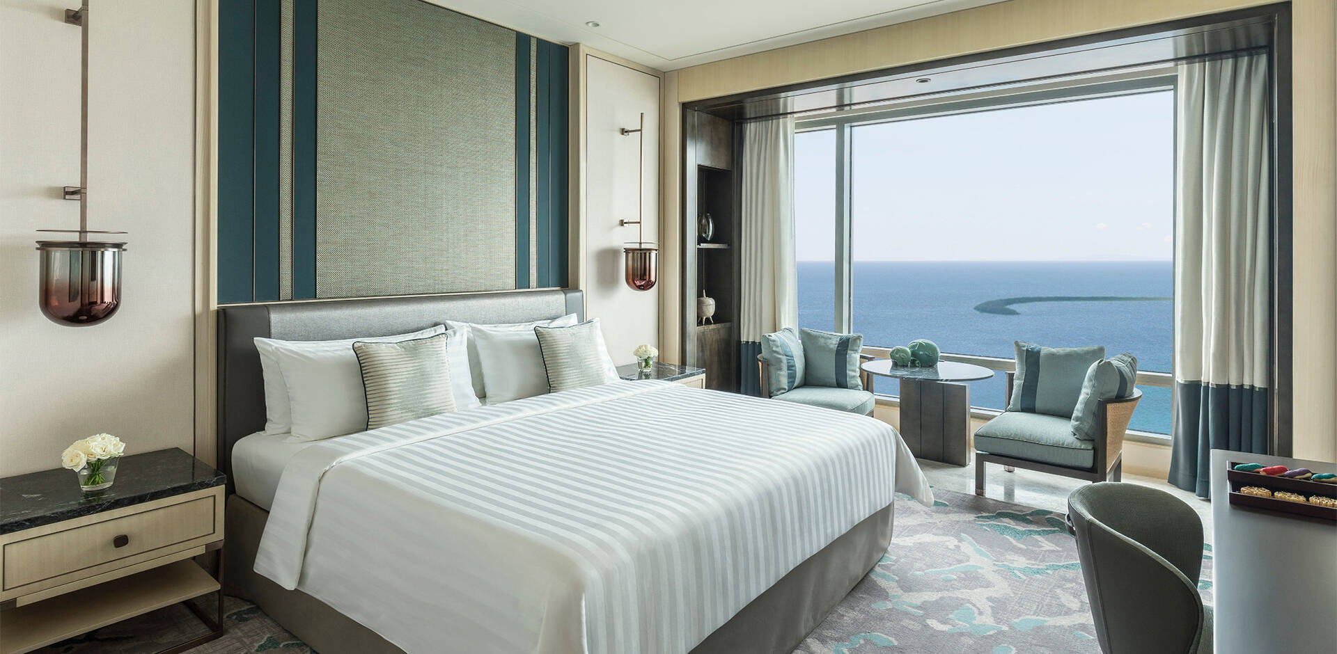 A Premier Ocean View Room, a king bed facing a wall of glass over the sea